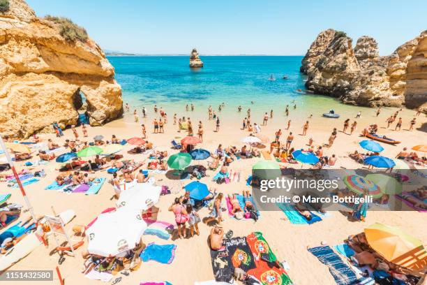 bathers on camilo beach, lagos, portugal - algarve portugal stock-fotos und bilder