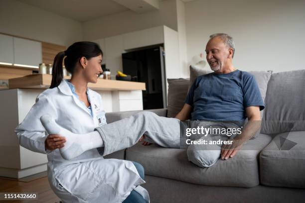 doctor making a home visit to a disabled senior patient - diabetic amputation stock pictures, royalty-free photos & images