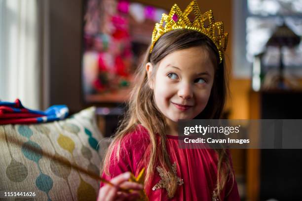 portrait of a cute happy little girl in a crown and fancy dress - girl gold dress stock pictures, royalty-free photos & images