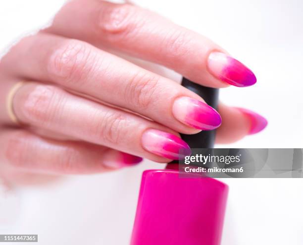 close-up of woman fingers with nail art manicure with pink colour - ombre stock-fotos und bilder