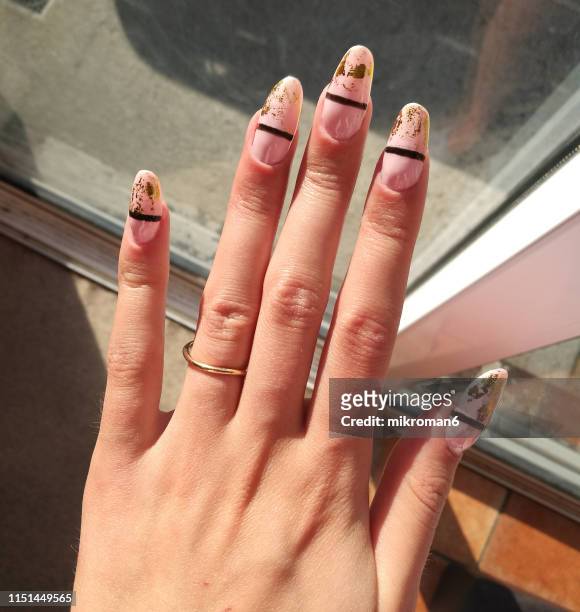close-up of woman fingers with nail art manicure in nude colour - manicure fotografías e imágenes de stock