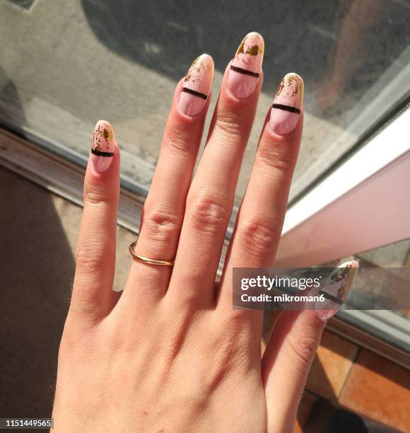 close-up of woman fingers with nail art manicure in nude colour - painting fingernails stock pictures, royalty-free photos & images