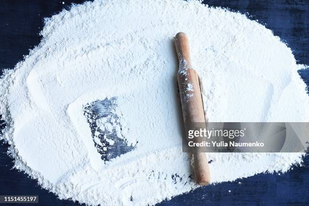 rolling pin and flour on a dark background. free space for text. top view. - mehl stock-fotos und bilder