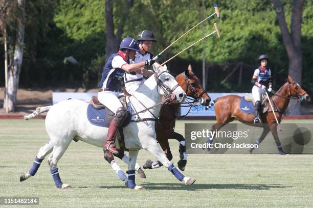 Harry, Duke of Sussex of Team Sentebale St Regis and Chet Lott of Team US Polo Assn tustle for the ball during the Sentebale ISPS Handa Polo Cup...