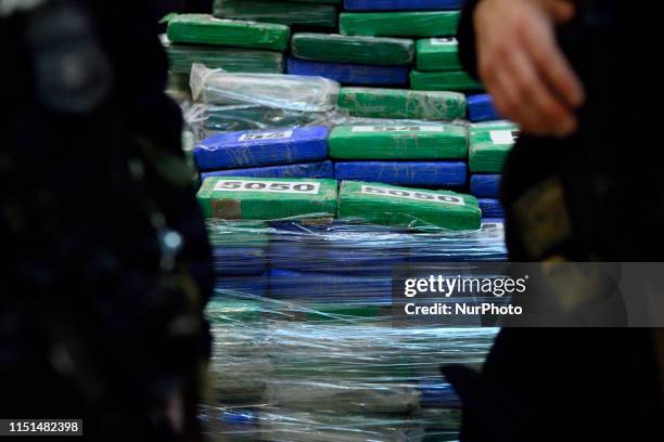 Heavily armed officers stand guard as law enforcement officials present a part of the evidence from a cocaine bust on the MSC Gayane in the port of...