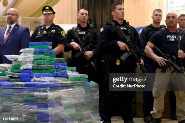 Heavily armed officers stand guard as law enforcement officials present a part of the evidence from a cocaine bust on the MSC Gayane in the port of...