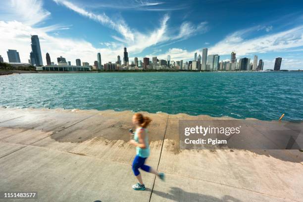 running on the lakefront trail chicago illinois - chicago lifestyle stock pictures, royalty-free photos & images