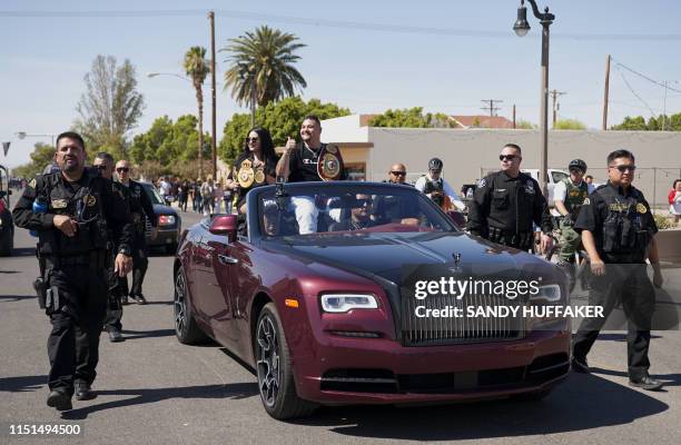 Heavyweight boxing champion Andy Ruiz Jr. And his wife Julie wave to supporters during a parade in his honour on June 22, 2019 in Imperial,...