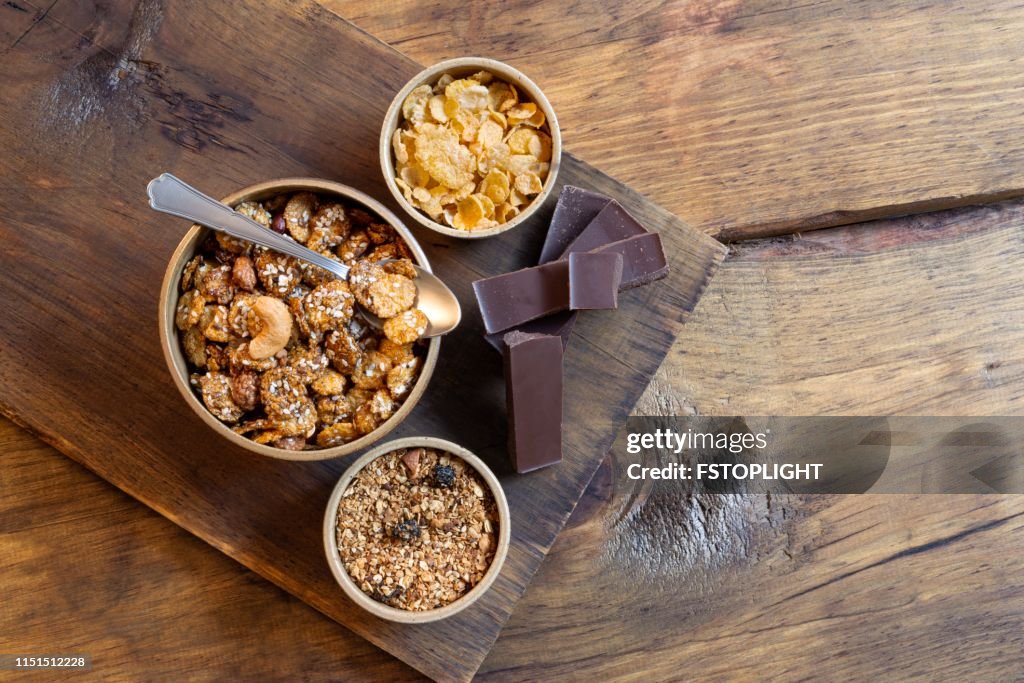Bowl with granola,corn flakes and dark chocolate bar.