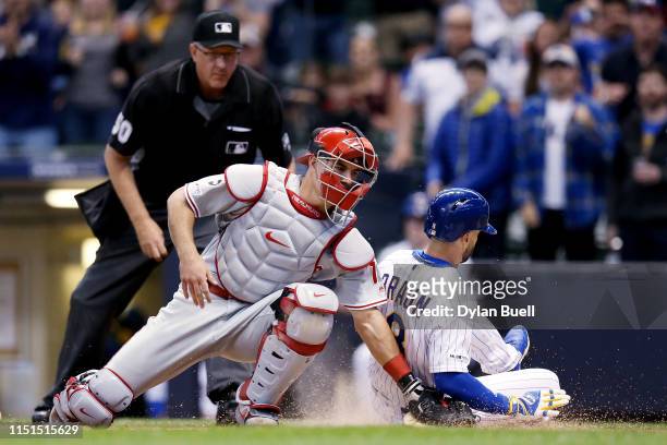 Ryan Braun of the Milwaukee Brewers slides into home plate to score a run past J.T. Realmuto of the Philadelphia Phillies in the first inning at...