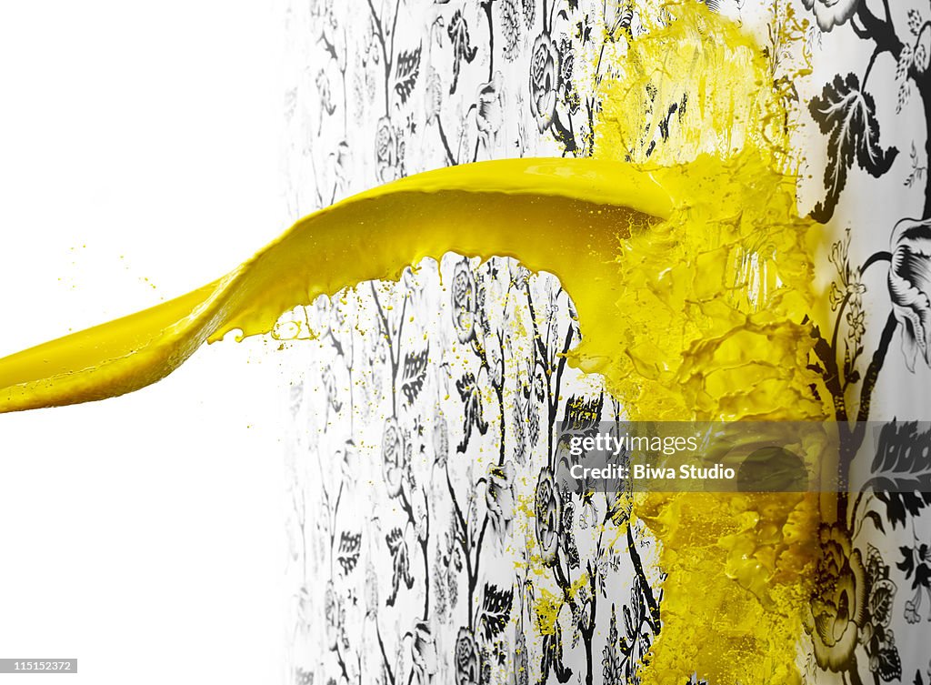 Yellow paint splattering on wallpaper