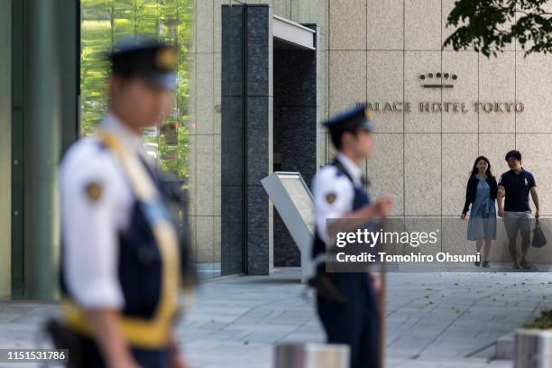 Couple walk past the Palace Hotel Tokyo as police officers stand guard on May 25, 2019 in Tokyo, Japan. U.S President Donald Trump will arrive later...