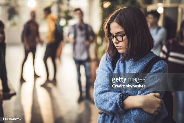 sad high school student feeling lonely in a hallway. - tristeza imagens e fotografias de stock