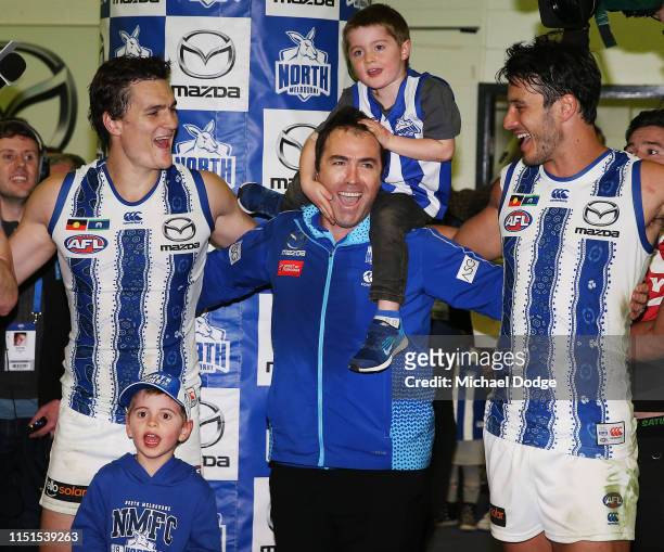 Kangaroos head coach Brad Scott sing the club song after winning with his son and Robbie Tarrant of the Kangaroos and Scott Thompson during the round...