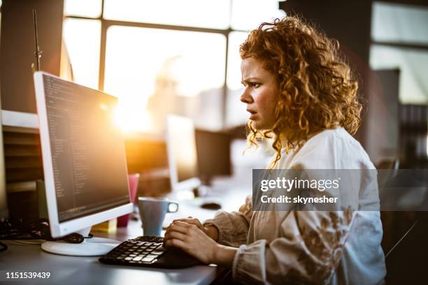 redhead female programmer having problems while coding software in the office. - web programmer stock pictures, royalty-free photos & images