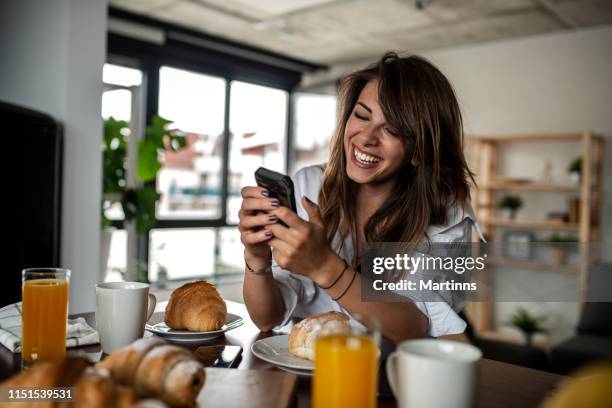 woman texting her friends at the breakfast table - roll call cup stock pictures, royalty-free photos & images