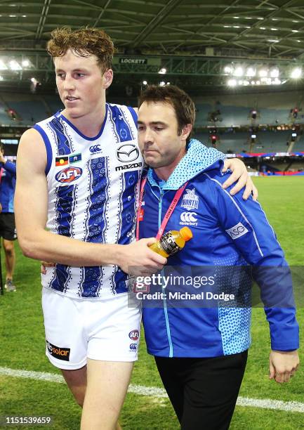 An emotional Kangaroos head coach Brad Scott is hugged after his win by Nick Larkey of the Kangaroos as they walk off during the round 10 AFL match...