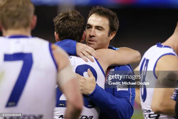 An emotional Kangaroos head coach Brad Scott is hugged after his win by Kayne Turner of the Kangaroos as they walk off during the round 10 AFL match...