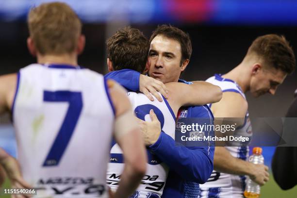 An emotional Kangaroos head coach Brad Scott is hugged after his win by Kayne Turner of the Kangaroos as they walk off during the round 10 AFL match...