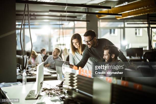grupo de programadores de computadoras felices trabajando juntos en pc de escritorio en la oficina corporativa. - information technology support fotografías e imágenes de stock