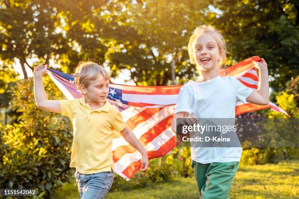 ee.uu. memorial o el concepto de día de la independencia con niña y niño sosteniendo banderas americanas - flag day fotografías e imágenes de stock