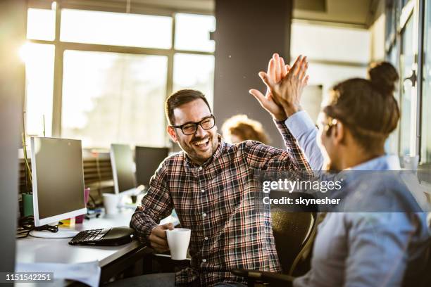 glückliche männliche programmierer geben sich gegenseitig hohe fünf im büro. - high five stock-fotos und bilder