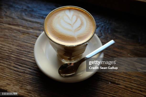 Flat white coffee, its milk froth poured into the shape of a plant's leaves, stands ready to drink in a coffee house on March 30, 2019 in Berlin,...