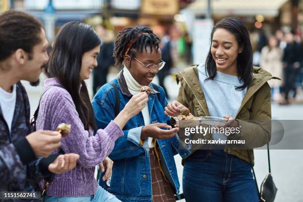 young friends enjoying street food in tokyo - takoyaki stock pictures, royalty-free photos & images