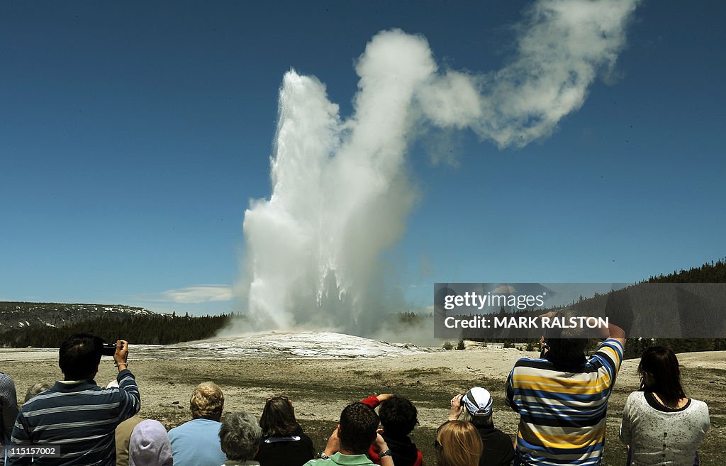 Tourists watch the 'Old Faithful' geyser