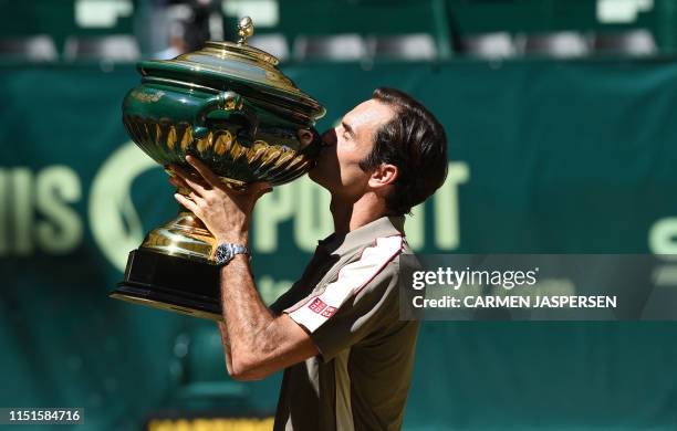 Roger Federer from Switzerland kisses the trophy after he won his final match against David Goffin from Belgium at the ATP tennis tournament in...