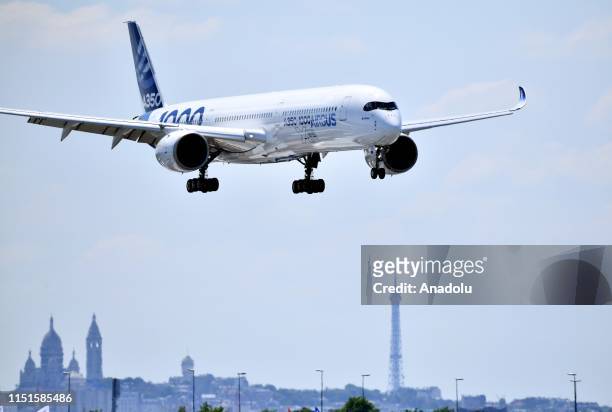 Silhouettes of The Eiffel Tower and The Sacre-Cur Basilica are seen as an Airbus A350 XWB aircraft performs during the 53rd International Paris Air...