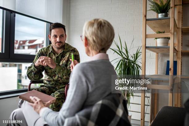 depressed soldier and his psychotherapist during a session - mental disability stock pictures, royalty-free photos & images