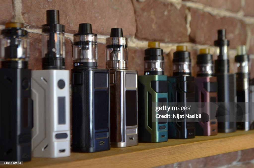 Electronic cigarette on a background of vape shop.