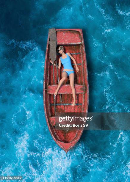 woman in old boat adrift in the open sea - encalhado - fotografias e filmes do acervo