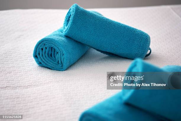 blue bright color bath towels on bed cover in hotel suite - folded towels stock pictures, royalty-free photos & images