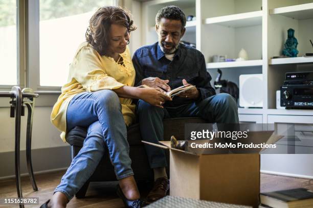 senior couple packing books to move - memories box stock pictures, royalty-free photos & images