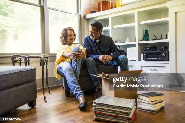 senior couple packing books to move - senior moving house stock pictures, royalty-free photos & images