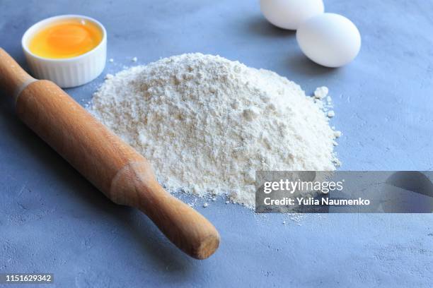 preparation of dough, flour, eggs and rolling pin on gray background. - dry pasta stock pictures, royalty-free photos & images