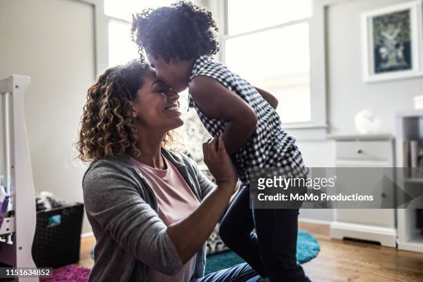 mother and daughter playing on bedroom floor - family selective focus stock pictures, royalty-free photos & images