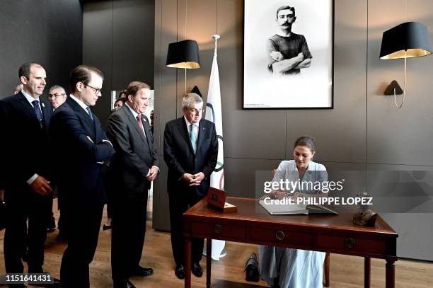 Crown Princess Victoria of Sweden signs the Livre d'or next to International Olympic Committee president Thomas Bach , Sweden's Prime Minister Stefan...