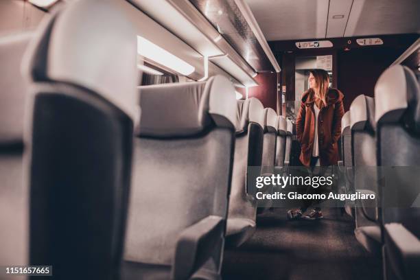 young woman walking among the seats on tgv train, paris, france, europe - tgv stockfoto's en -beelden