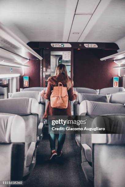 young woman walking among the seats on tgv train, paris, france, europe - tgv stockfoto's en -beelden