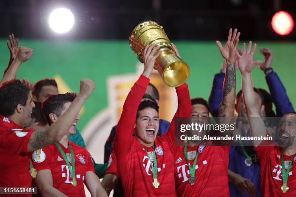 James Rodriguez of Bayern Munich celebrates with the DFB Pokal following his team's victory in the DFB Cup final between RB Leipzig and Bayern...