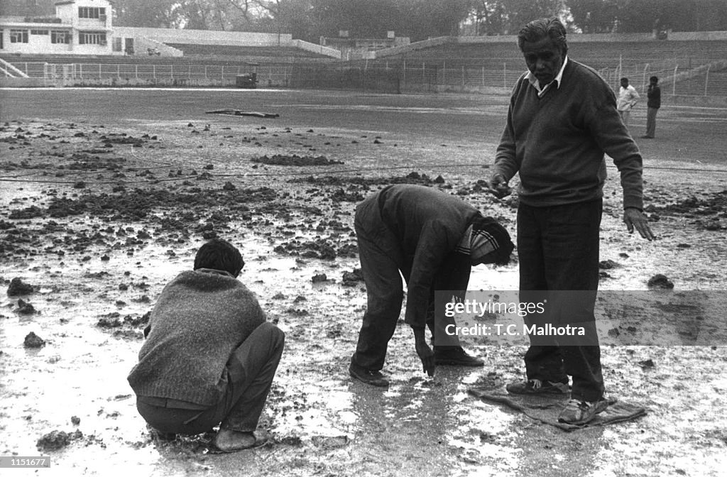 Groundmen inspect a 22-yard strip