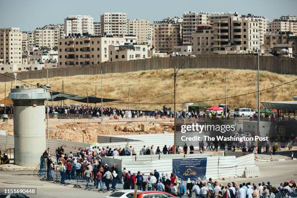 May 17: Houses at the Qalandiya refugee camp and a section of Israel's separation wall are seen in the background, as Palestinians cross Qalandiya...