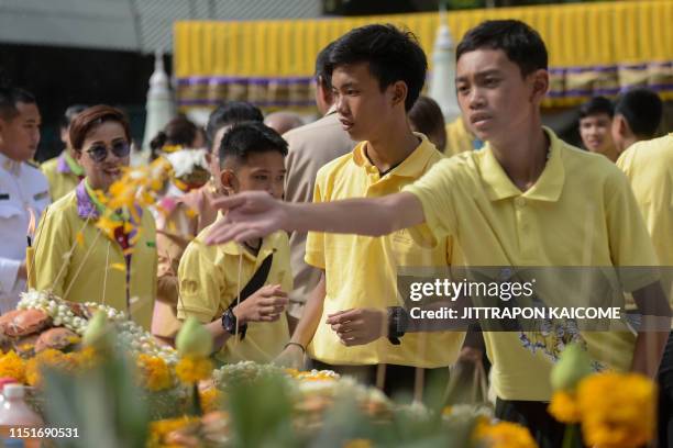 Members of the "Wild Boars" football team take part in a ceremony to mark the first anniversary of their rescue from the Tham Luang cave in the Mae...