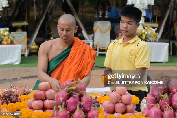 Member of the "Wild Boars" football team prepares flowers for a traditional ceremony to mark the first anniversary of their rescue from the Tham...