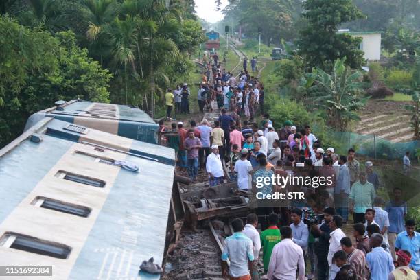 Bangladeshi onlookers gather around a derailed train after a bridge collapse in Kulaura on June 24, 2019. - A train plunged into a canal when the...