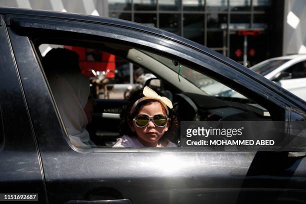 Palestinian girl looks out of a car window in Gaza City on June 24, 2019. - Finance officials were flying into Bahrain today for a US-led peace...