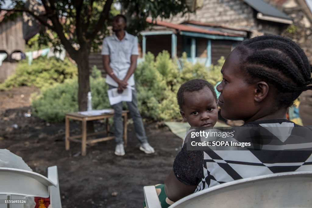 A woman with her kid attend a community meeting aimed at...